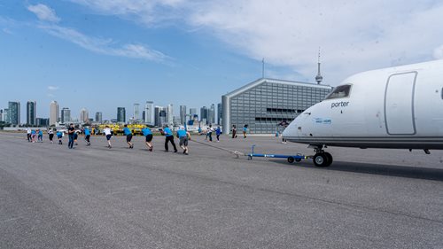 Hope-Air-144.jpg Group of individuals pulling an airplane using a rope